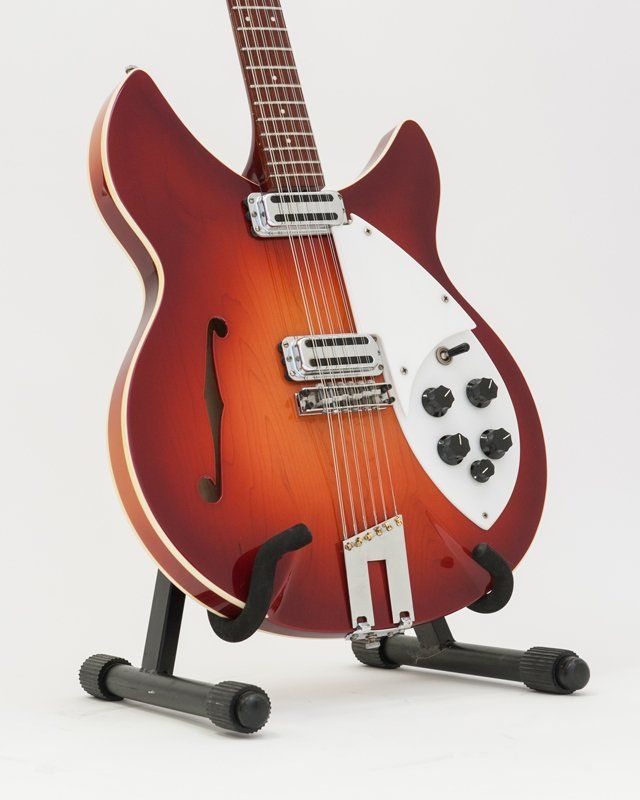 A guitar is sitting on a stand against a white background