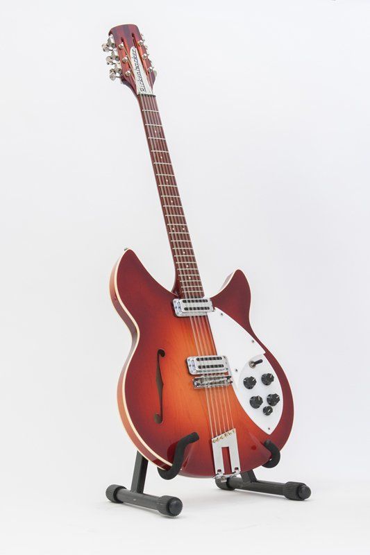 A guitar is sitting on a stand on a white background