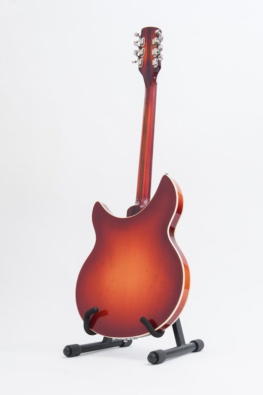 A guitar is sitting on a stand on a white background.