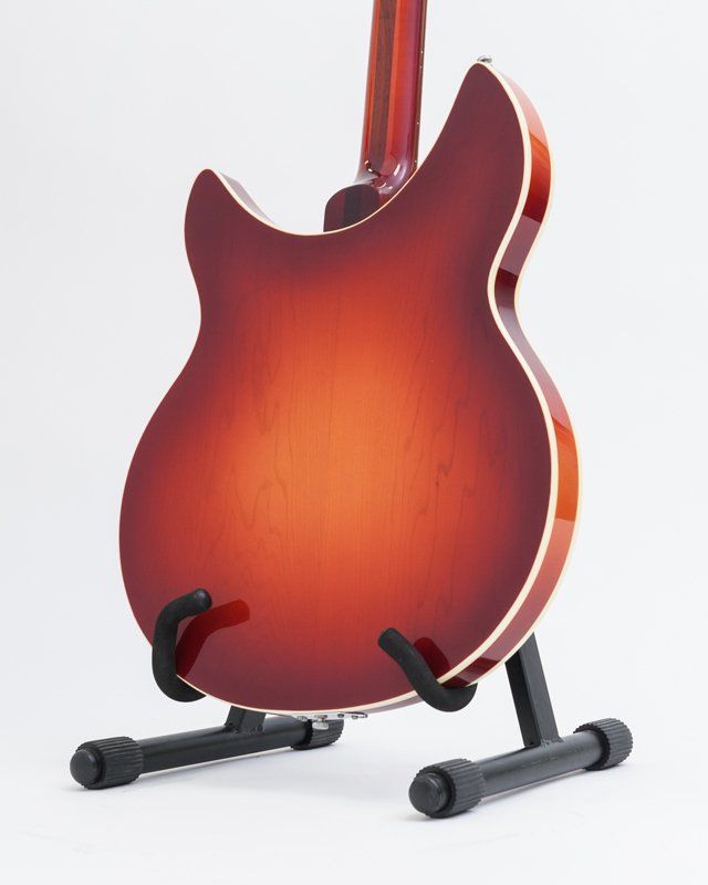 A red guitar is sitting on a black stand