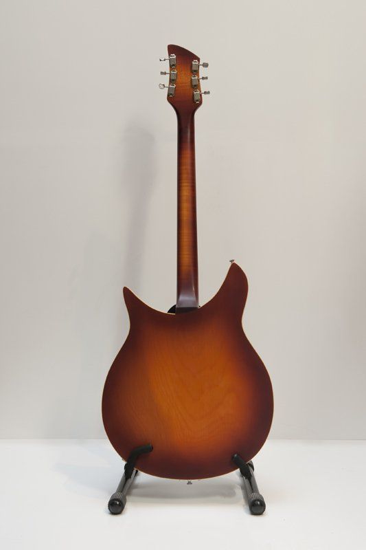 The back of a guitar is shown on a stand