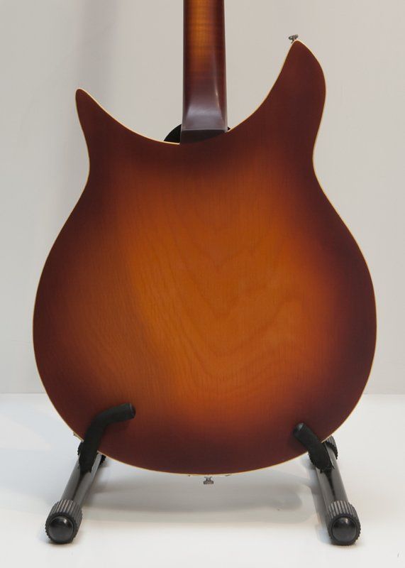 The back of a guitar is shown on a stand