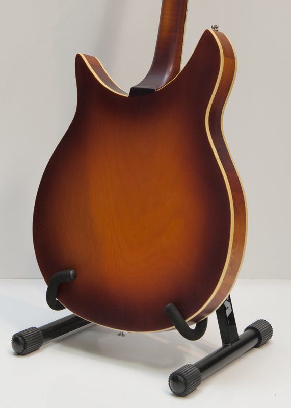 The back of a guitar is shown on a stand