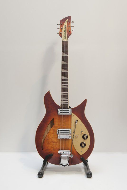 A guitar is sitting on a stand on a table