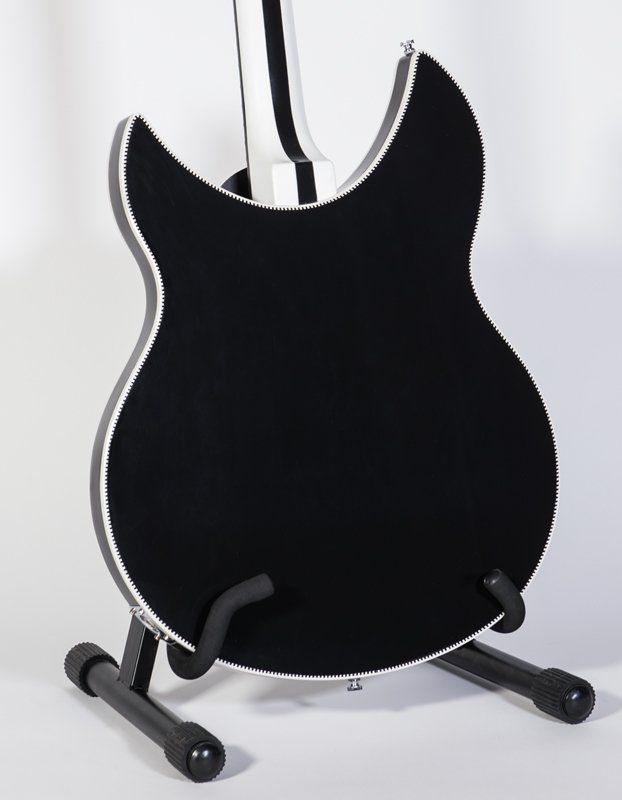 A black guitar is sitting on a black stand