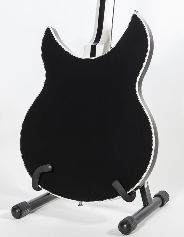 A black guitar is sitting on a stand on a white background