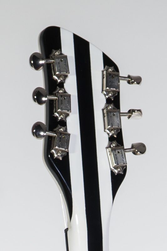 The headstock of a black and white striped guitar