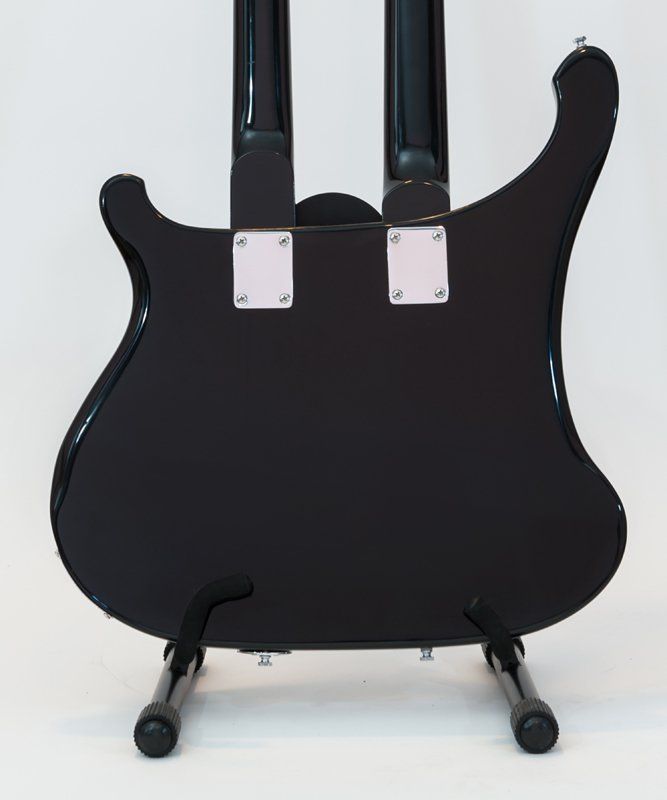 A black double neck guitar is sitting on a stand