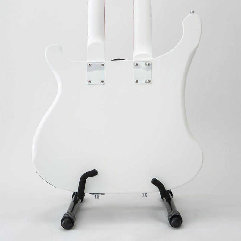 A white guitar is sitting on a black stand