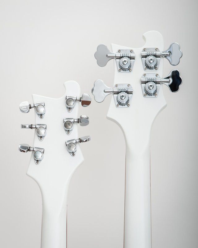 A couple of white guitars are sitting next to each other