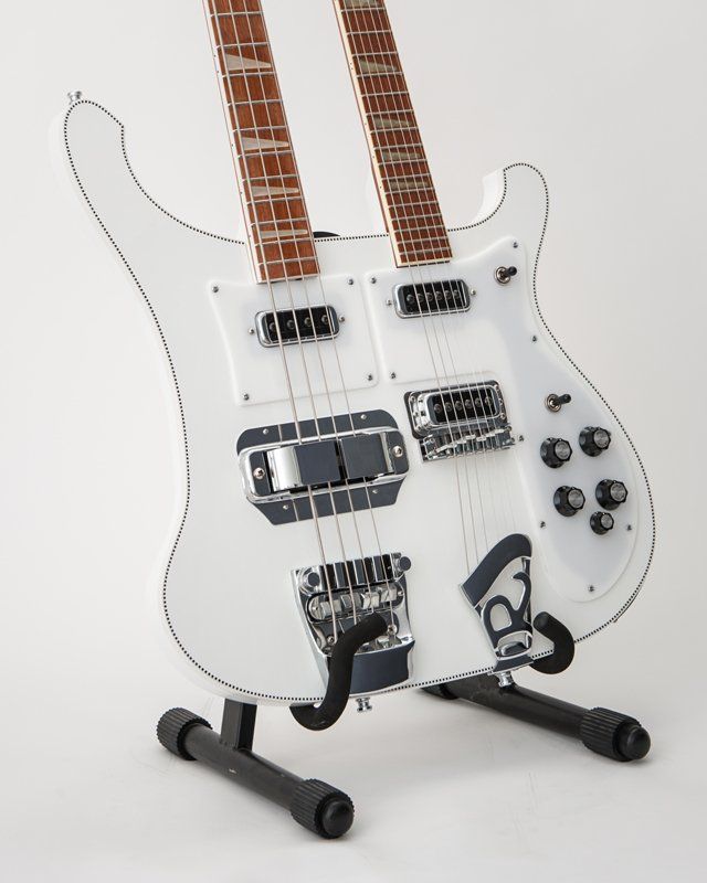 A white double neck bass guitar on a stand