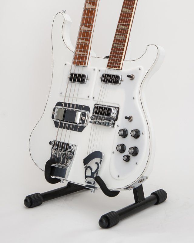 A white double neck guitar is sitting on a black stand