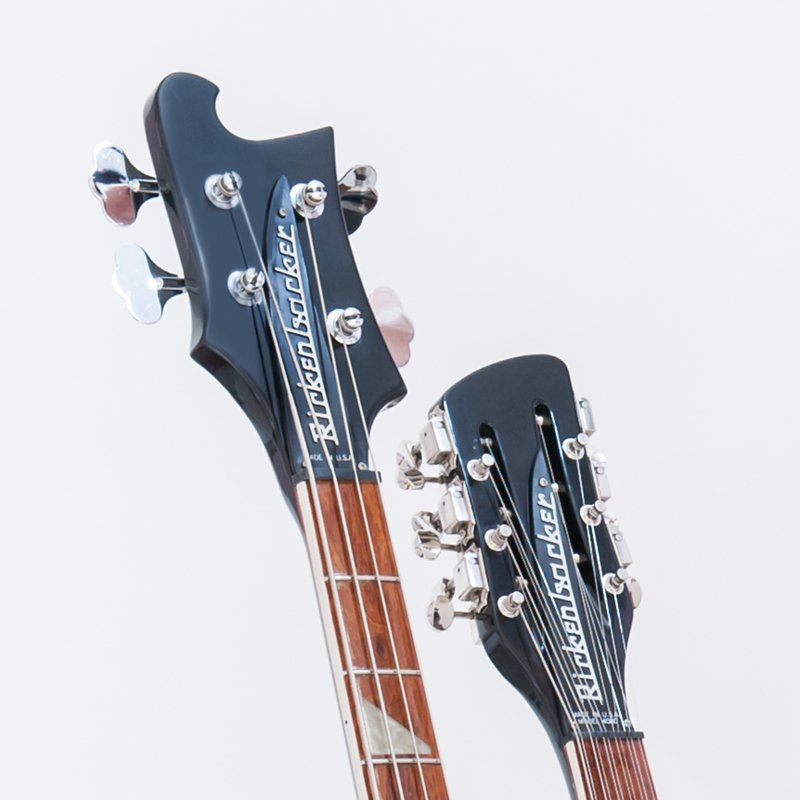 Two rickenbacker guitars are sitting next to each other