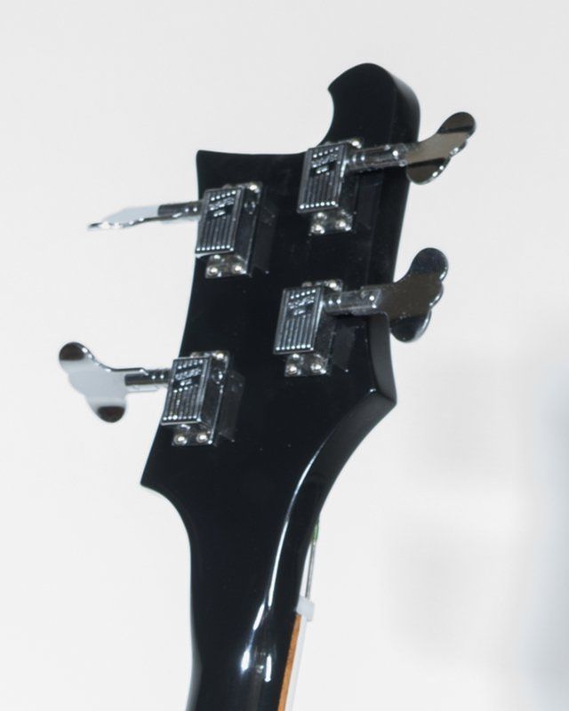 A close up of the headstock of a bass guitar