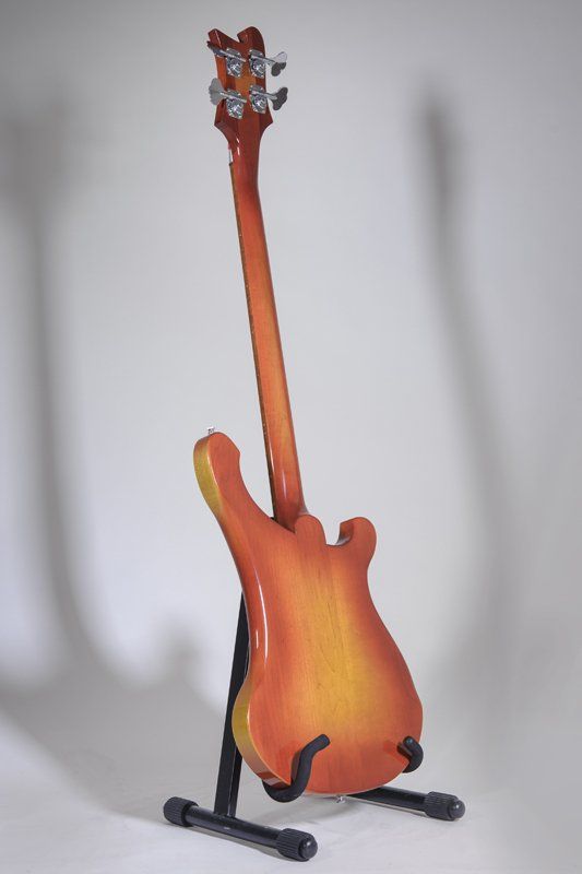 A guitar is sitting on a stand against a white background