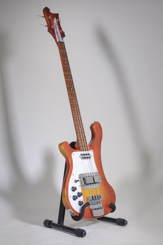 A guitar is sitting on a stand on a white background.