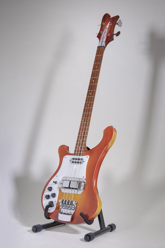 A red electric guitar is sitting on a stand.