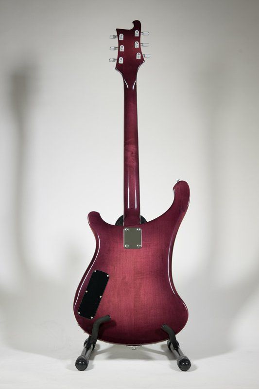 The back of a purple electric guitar on a stand