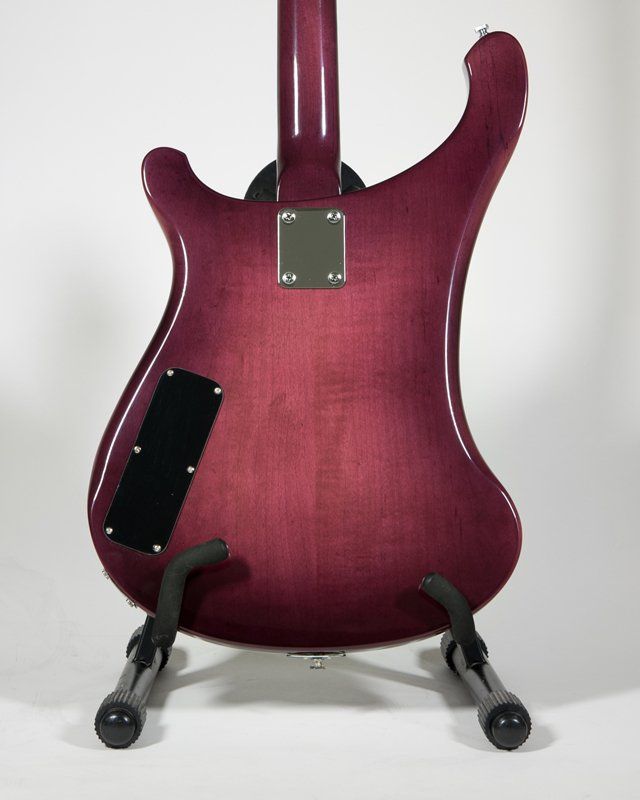 The back of a purple electric guitar on a stand