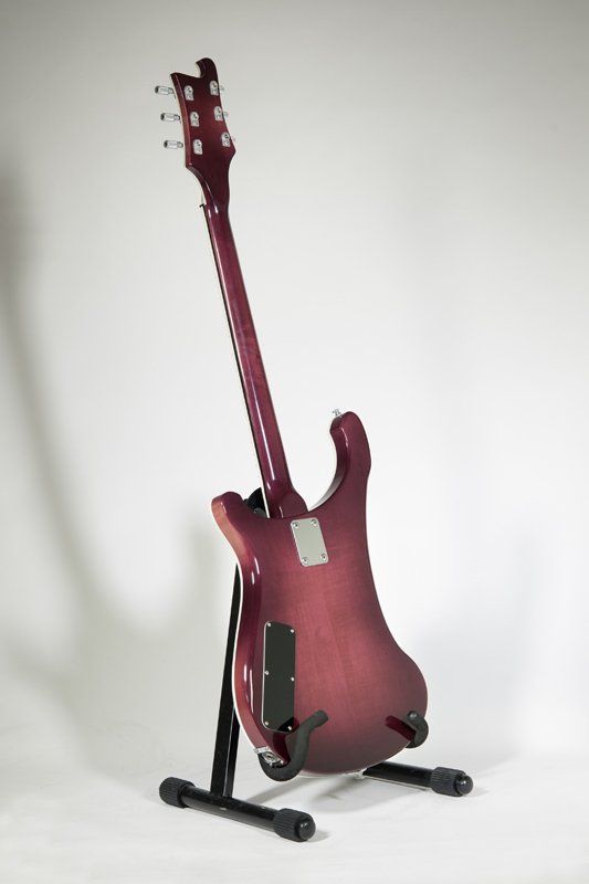A red electric guitar is sitting on a stand