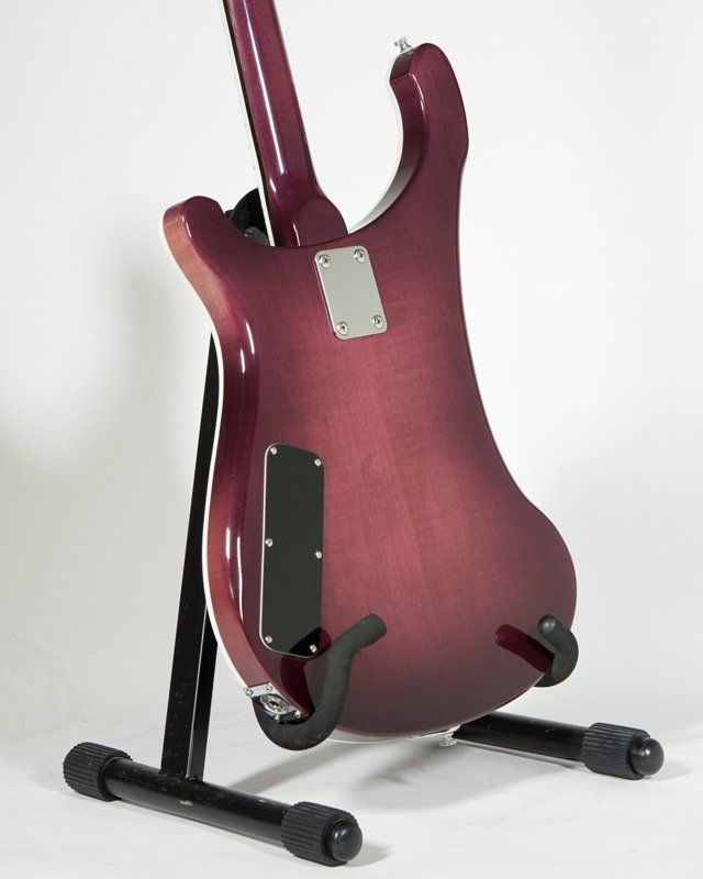 A red guitar is sitting on a black stand