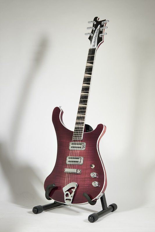 A purple electric guitar is sitting on a stand.