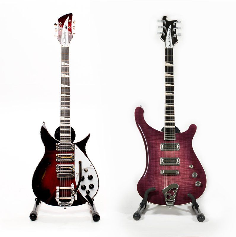 Two electric guitars are sitting next to each other on a stand.