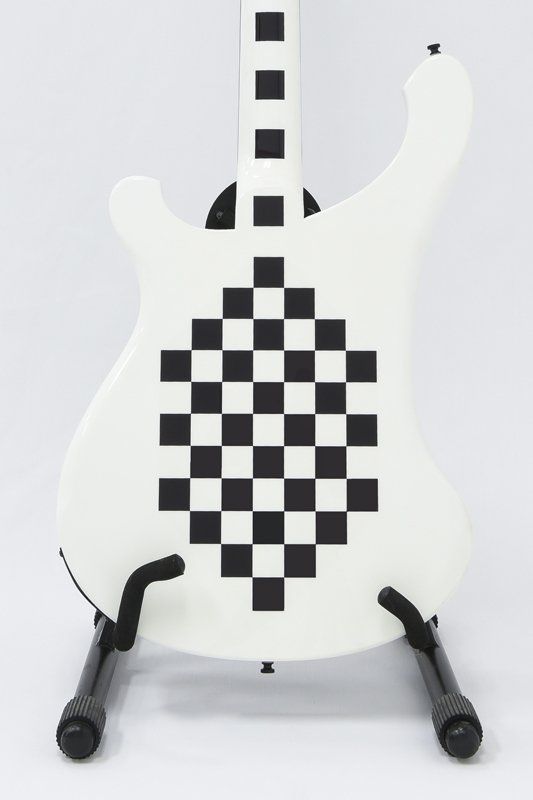 A white guitar with a black and white checkered pattern on it