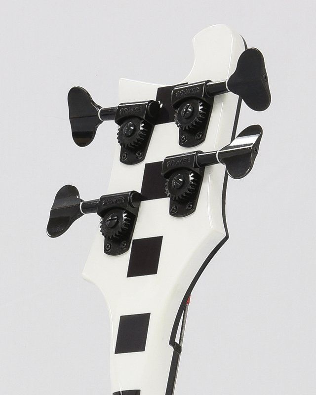 A close up of a black and white bass guitar headstock