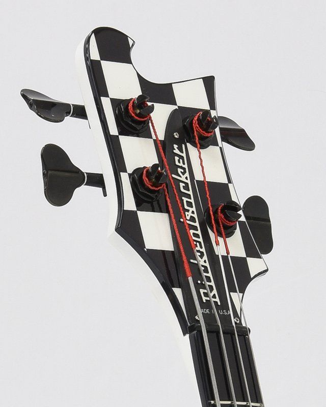The headstock of a black and white rickenbacker bass guitar