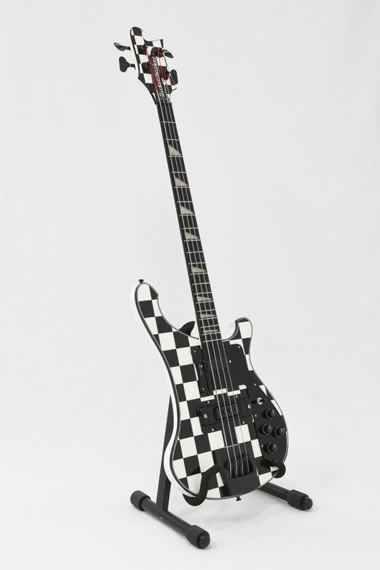 A black and white checkered guitar is on a stand