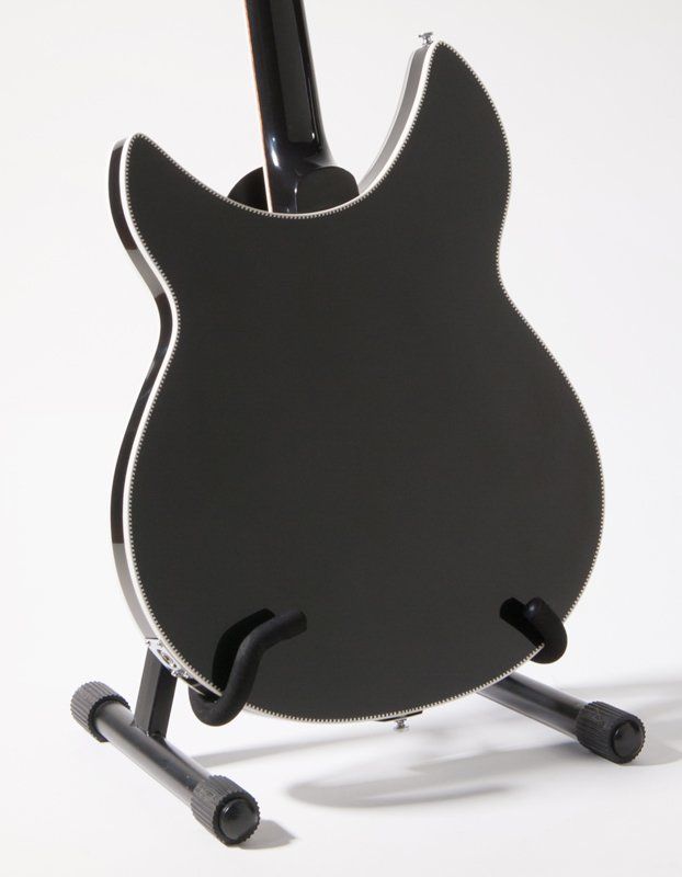 The back of a black guitar on a stand
