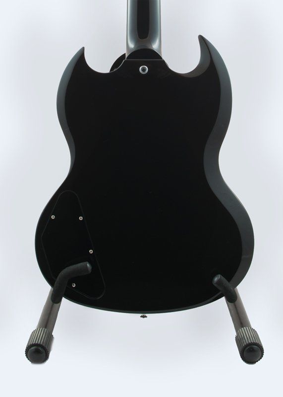 The back of a black guitar is shown on a stand