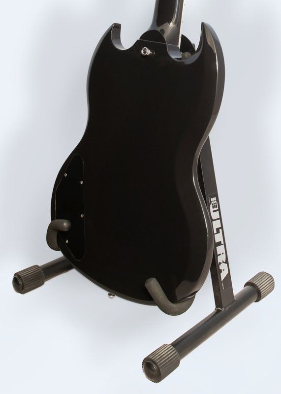 A black guitar is sitting on an ultra guitar stand