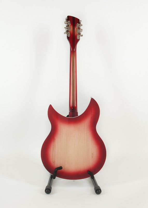 A red guitar is sitting on a stand on a white background.
