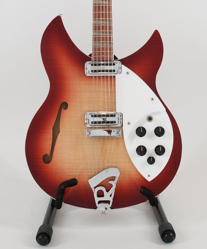 A rickenbacker guitar is sitting on a stand