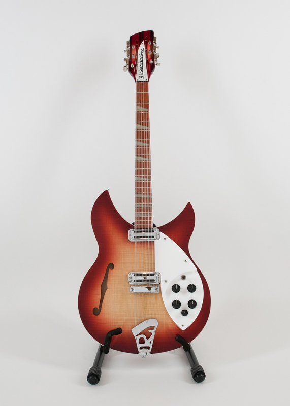A rickenbacker guitar is sitting on a stand