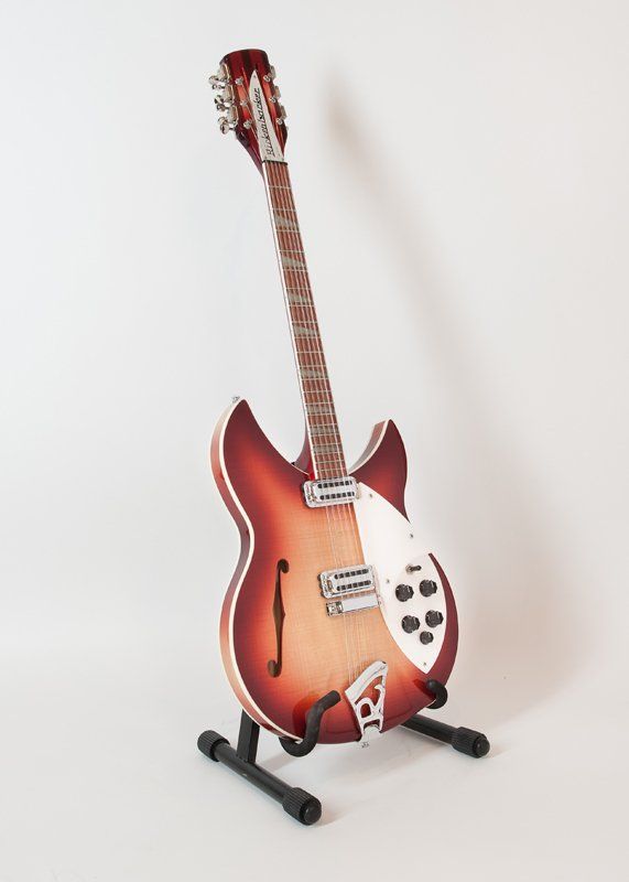 A guitar is sitting on a stand on a white background