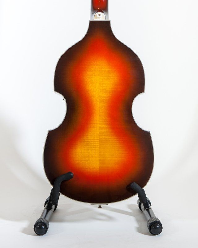 A double bass is sitting on a stand on a white background