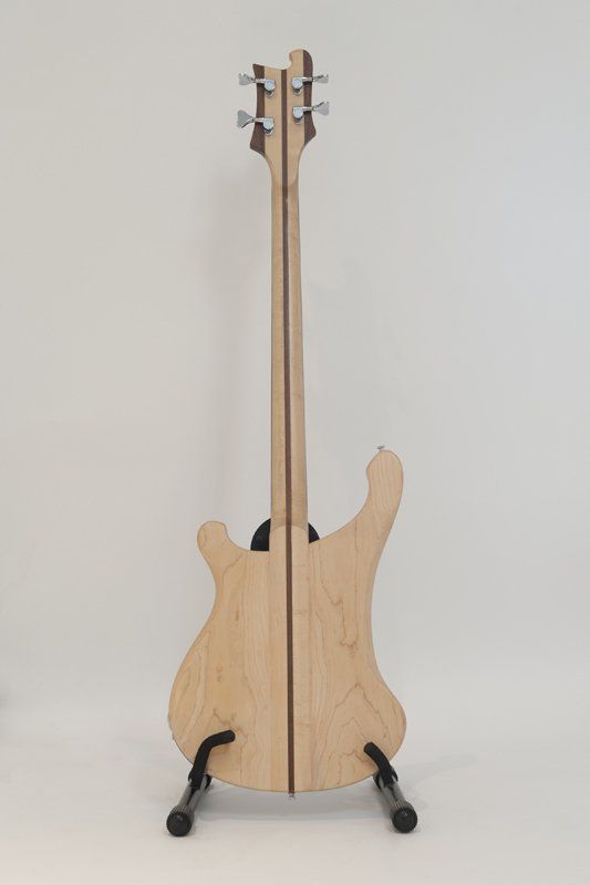 The back of a bass guitar is shown on a stand.