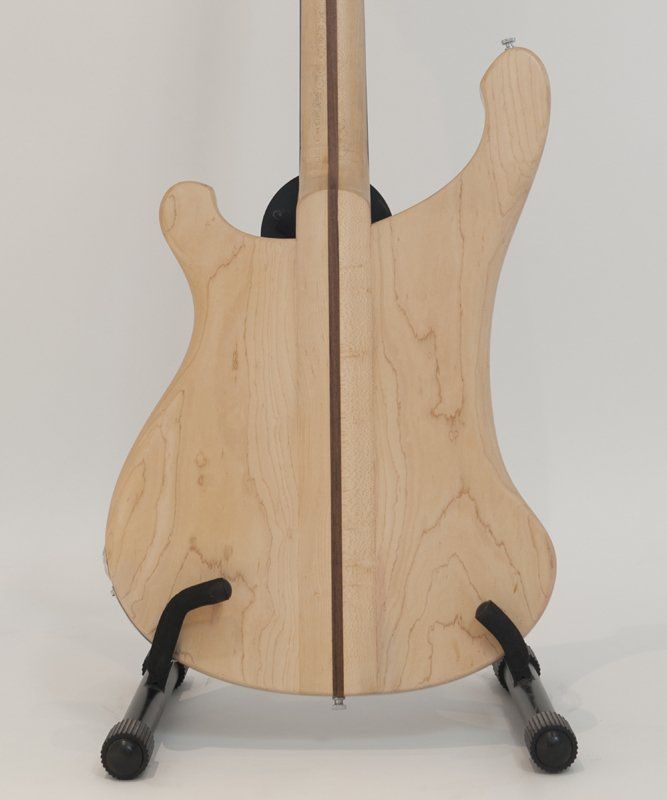 The back of a guitar is shown on a stand