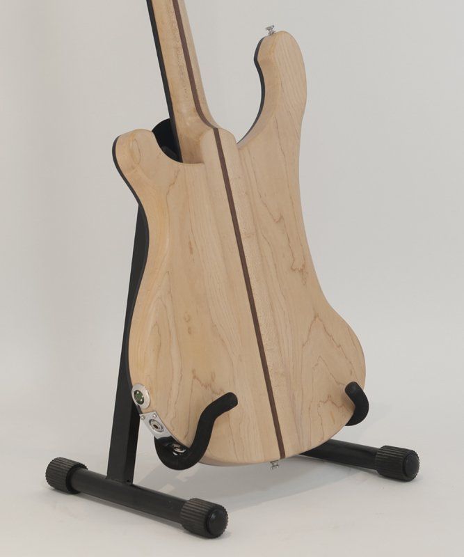 The back of a guitar is shown on a stand