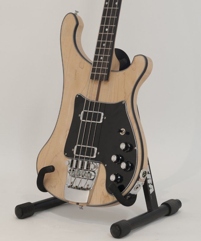 A miniature bass guitar is sitting on a stand