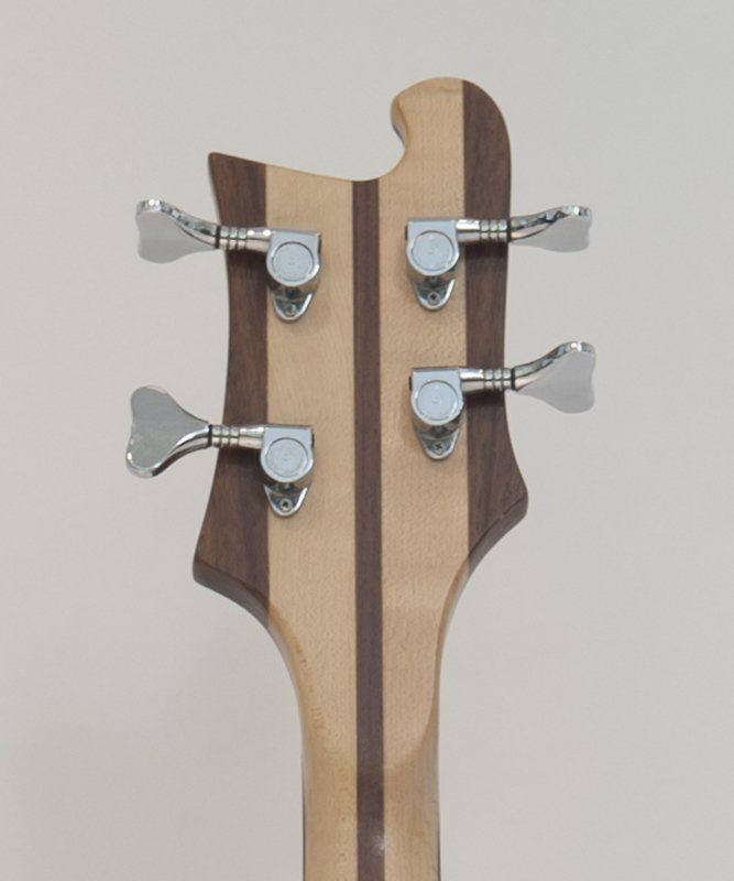 A close up of the headstock of a bass guitar