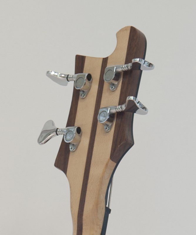 A close up of the headstock of a bass guitar