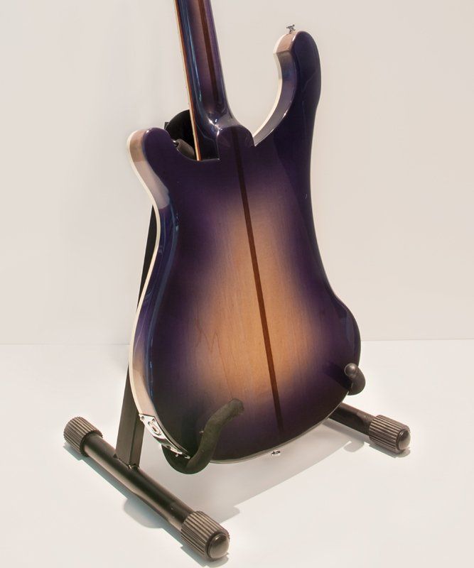 A purple and brown guitar is sitting on a stand