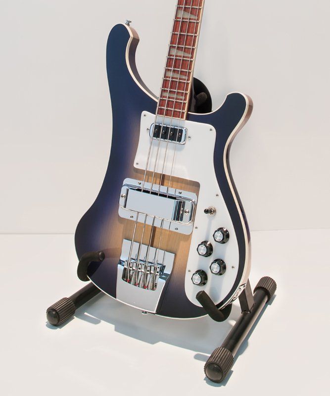 A blue and white electric guitar is sitting on a stand