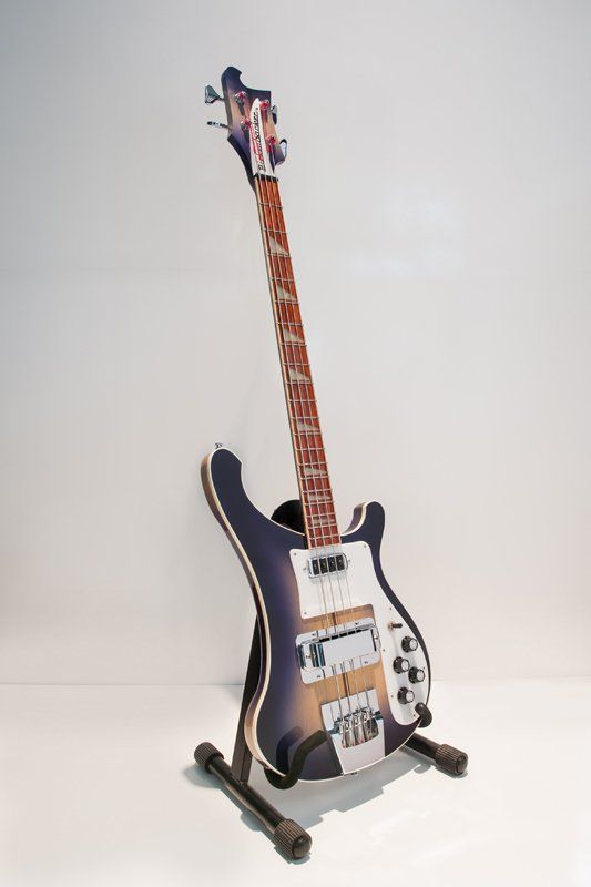 A guitar is sitting on a stand on a white surface