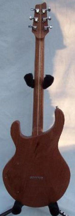 A guitar is sitting on a stand on a white surface.