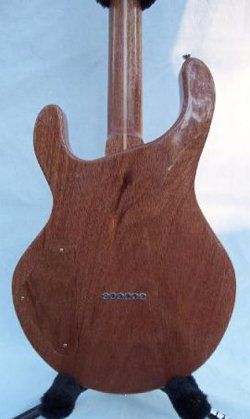 The back of a guitar is shown on a stand.